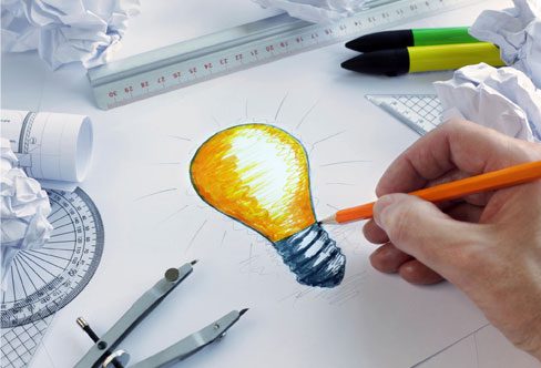 A person drawing an image of a light bulb.