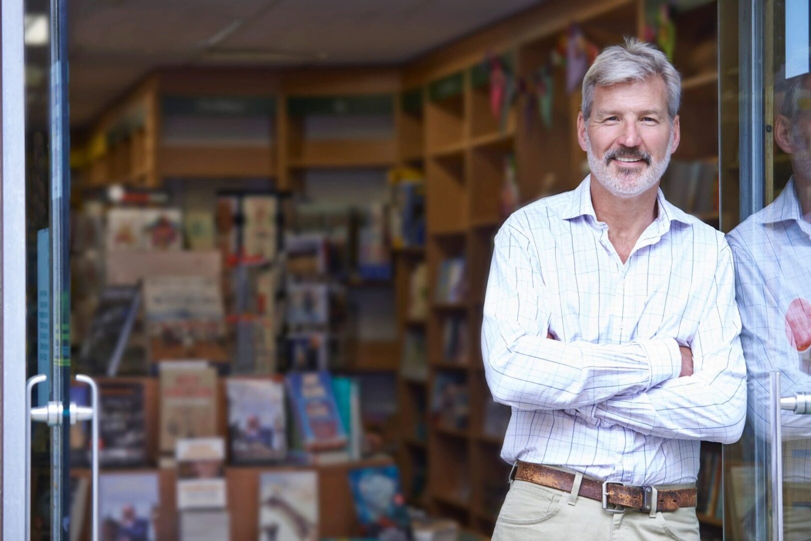 A man standing in front of shelves with books.