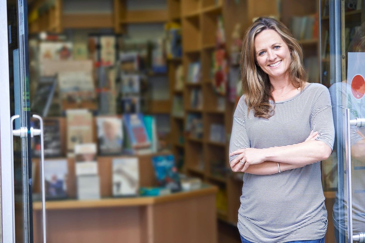 A woman standing in front of books and papers.